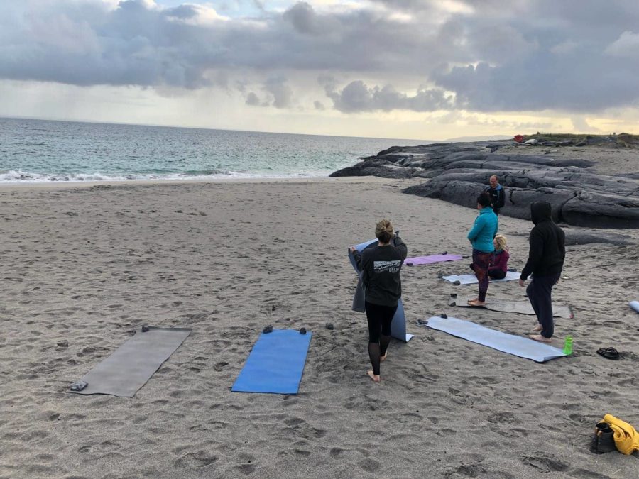 people doing yoga on the beach