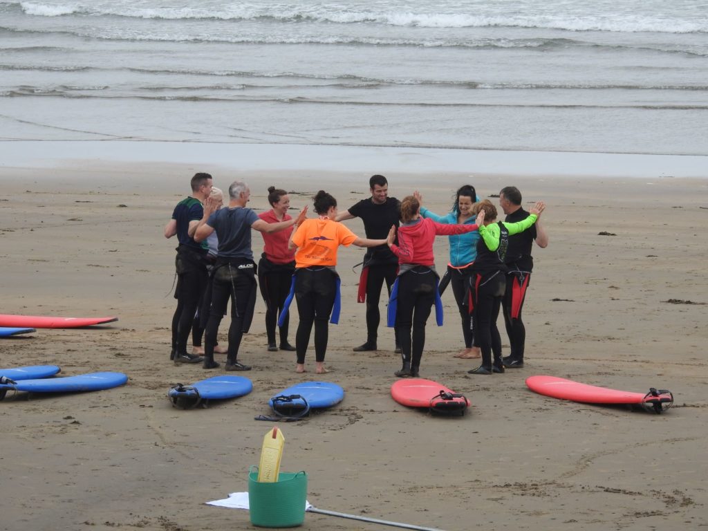 people standing in the circle on the beach