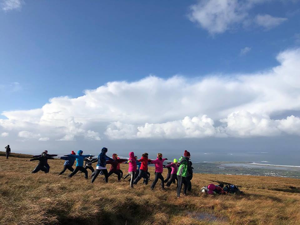 People practicing yoga on the mountain